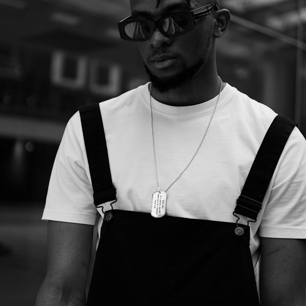 Man in streetwear met dog tag ketting, zwart-wit